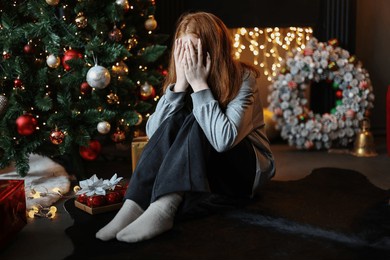 young beautiful depressed and sad girl sitting alone for christmas eve