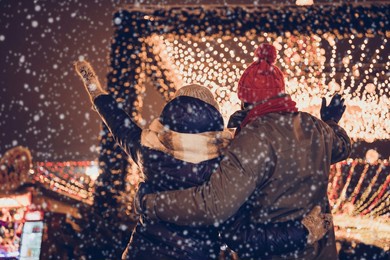 rear back behind view portrait of attractive couple having fun visiting eve carnival party midnight city urban outdoors