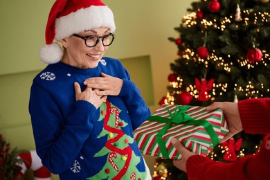 photo of cute lovely senior woman wear blue pullover receive christmas gift magic new year cosy atmosphere xmas spirit indoors