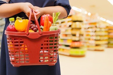 woman holding shopping basket in supermarket