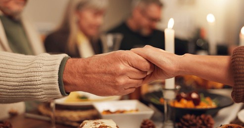 thanksgiving, people and holding hands with prayer for dinner, festive feast and holiday at home. closeup, family and together with grace for spiritual connection, blessing and christian with meal