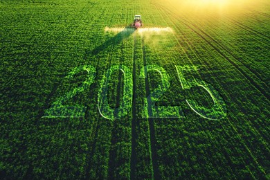 2025 happy new year concept and aerial view of farming tractor plowing and spraying on green field.