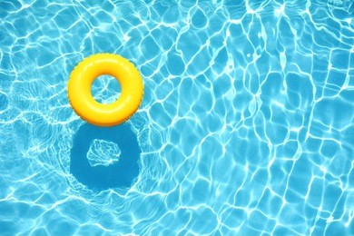yellow pool float, ring floating in a refreshing blue swimming pool