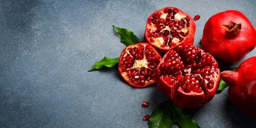 close up. sliced ​​ripe red pomegranate on a gray concrete background. top view.