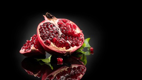pomegranate. fresh juicy pomegranates with leaves isolated on black background with reflection. organic bio fruits closeup. studio shot