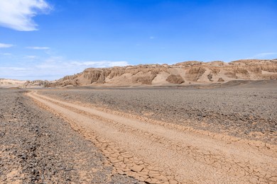 desert dirt road and mountain natural landscape in xinjiang, china. road trip in no man's land. outdoor natural background.
