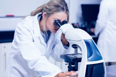 science student looking through microscope in the lab at the university