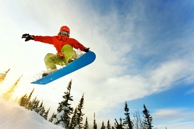 snowboarder jumping through air with deep blue sky in background