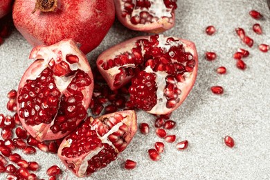 pomegranate seeds and pomegranates on a stone gray background close-up.