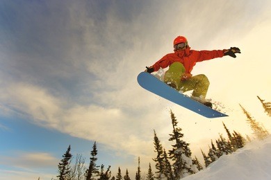 snowboarder jumping through air with deep blue sky in background