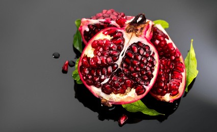 pomegranate. fresh juicy pomegranates with leaves on a dark gray background. organic bio fruits closeup. studio shot, top view