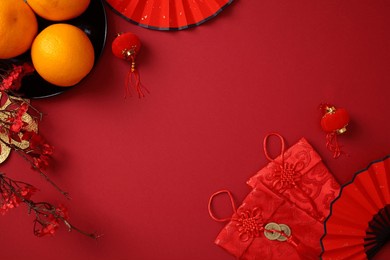 chinese new year 2025 flat lay composition with tangerines, cherry blossoms, red paper fans, lanterns on red background
