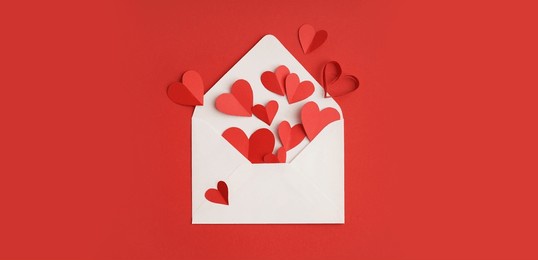 paper hearts and envelope on red background. valentine's day celebration