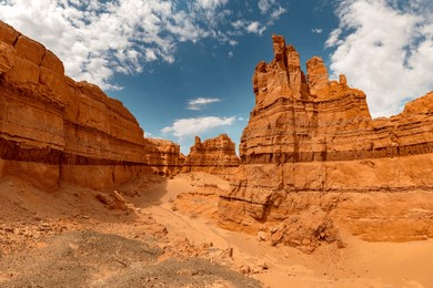 big limestone walls of big mongolian grand canyon khermen tsav against blue sky. gobi desert, mongolia