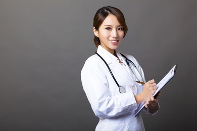 cheerful female doctor with clipboard 