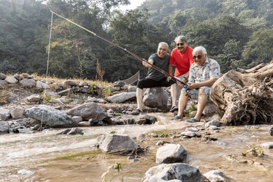 week-ed activities between senior friends. fishing on the river, at sunset.