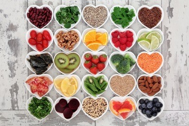 diet detox super food selection in heart shaped porcelain bowls over distressed wooden background.