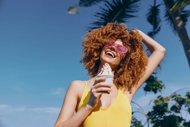 happy woman enjoying ice cream in sunny tropical setting with palm trees