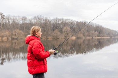 fishing on the lake. woman catches fish with a fishing rod