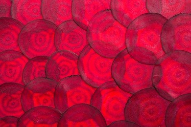 red beetred beets sliced in the background takes up the entire frame