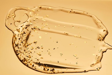 a delicious drop of 24k gold serum on a gold background.