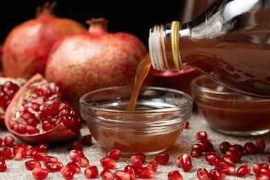natural pomegranate vinegar pour from bottle into glass bowl.