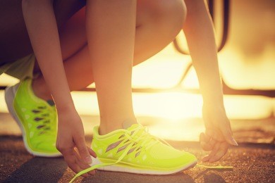 running shoes. barefoot running shoes closeup. female athlete tying laces for jogging on road in minimalistic barefoot running shoes. runner getting ready for training. sport lifestyle.