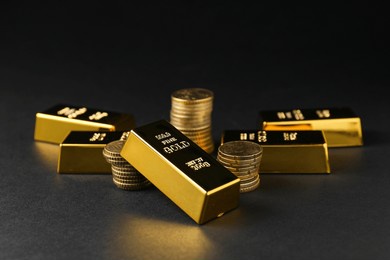 gold bars and coins on black table, closeup