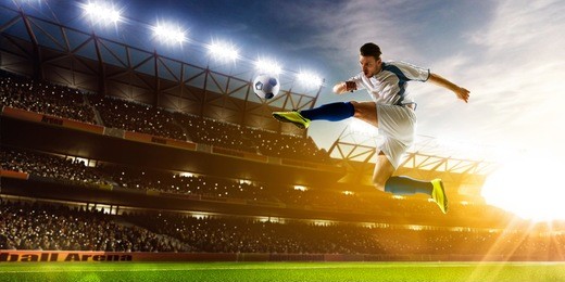 soccer player in action on night stadium background panorama