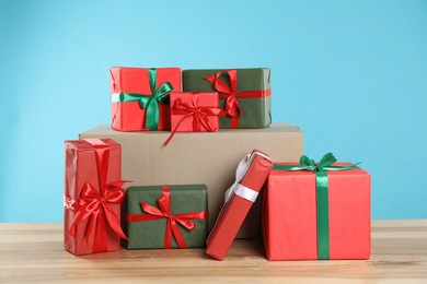parcel with gift boxes on wooden table against light blue background