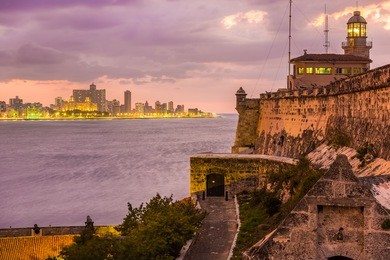 beautiful sunset in havana with el morro lighthouse illuminated on the foreground