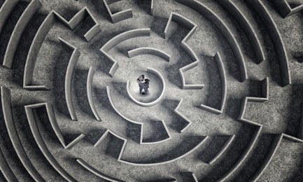puzzled businessman standing in center of labyrinth