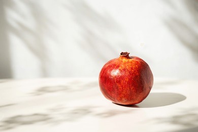 single pomegranate in soft natural light with interesting shadows.