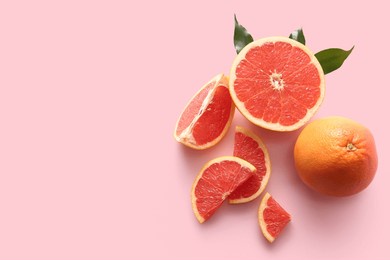 fresh ripe grapefruits and leaves on pink background