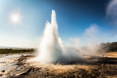 geysir, geyser park in iceland. stokkur eruption with sunstar in a beautiful sunny day 