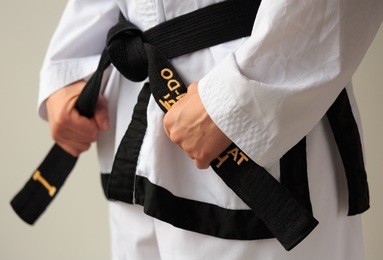 taekwon-do woman with black belt getting ready for training.
