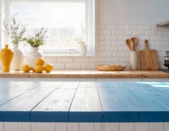 empty wooden table with the bright blue interior minimal of the kitchen as a blurred background behind the bokeh golden sunshine
