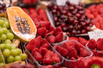 fresh strawberries, grapes, cherries, and sliced papaya displayed in rustic baskets at a vibrant farmers market, showcasing colorful, organic, and healthy produce.