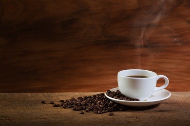 coffee cup and coffee beans with stream on old wooden background