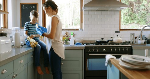 home, cleaning and mother with boy, help or learning with chores, washing dishes or healthy hygiene. parent, mom or son in kitchen, child development or conversation with housekeeping or remove dirt