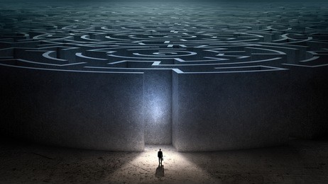 puzzled businessman standing near entrance of labyrinth