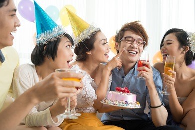 friends having fun with cake at party