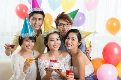 young woman celebrating birthday with her friends at home