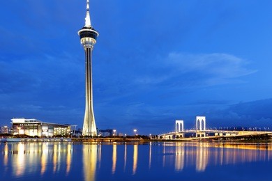 urban landscape of macau with famous traveling tower under sky near river in macao, asia.