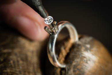 craft jewelery making. ring repairing. putting the diamond on the ring. macro shot.