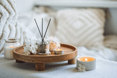 aroma diffuser, burning candle, blooming hyacinth flowers and perfume on wooden bamboo tray. cozy home decor, hygge and aromatherapy concept. comfortable atmosphere, spring delicious fresh smell