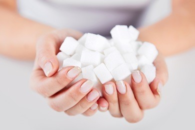 woman holds in hands of a handful of sugar cubes