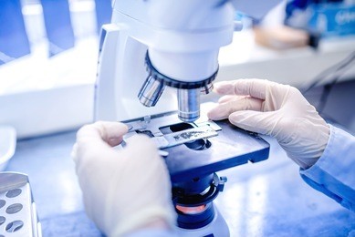 scientist hands with microscope, examining samples and liquid. medical research with technical equipment