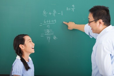 teacher with a little girl discussing  in classroom