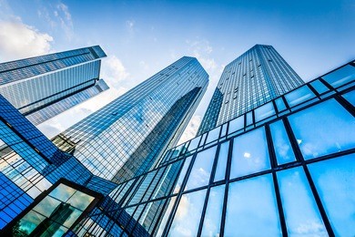 bottom view of modern skyscrapers in business district against blue sky